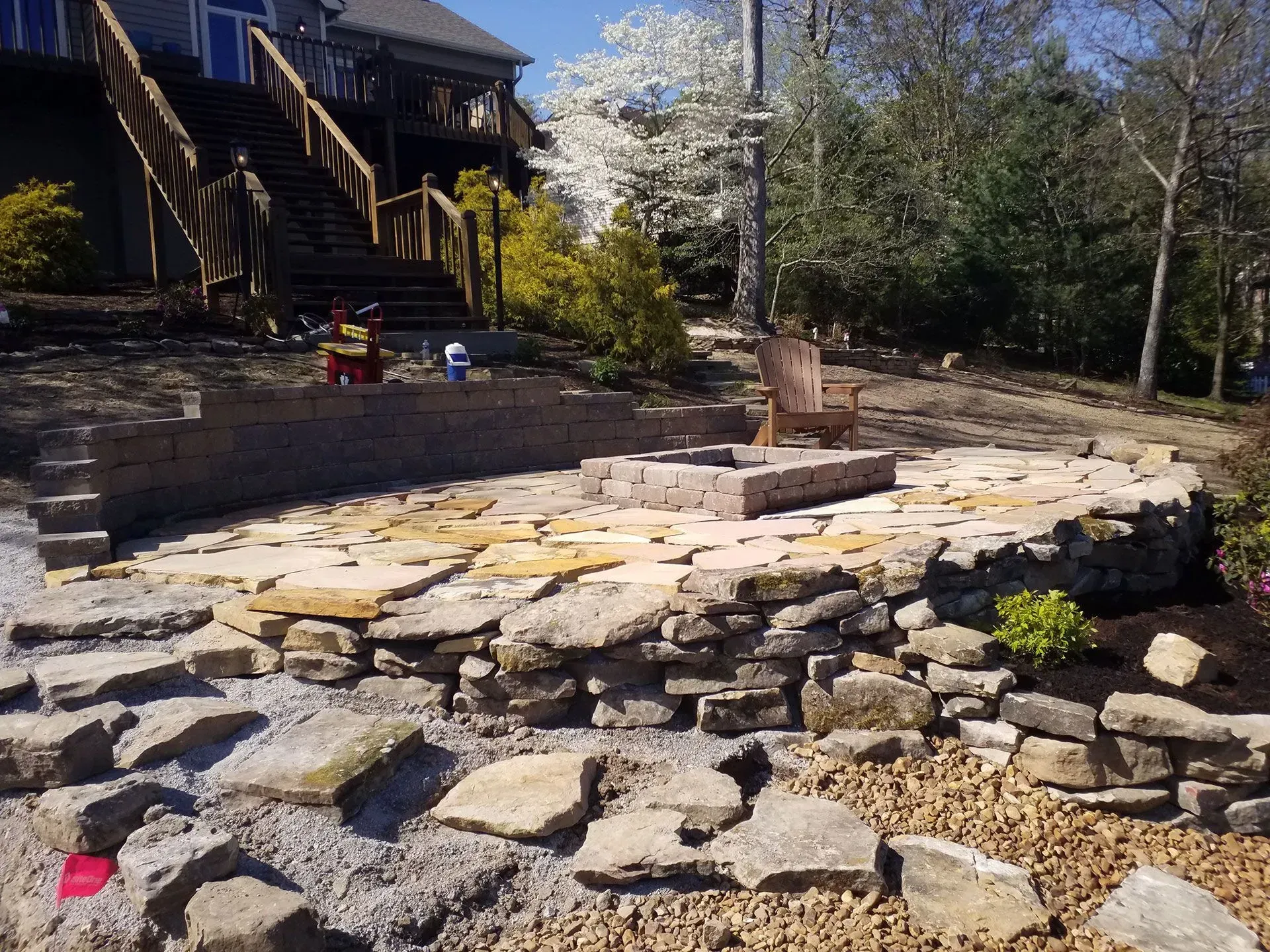 A house with stairs and a rock wall in front of it