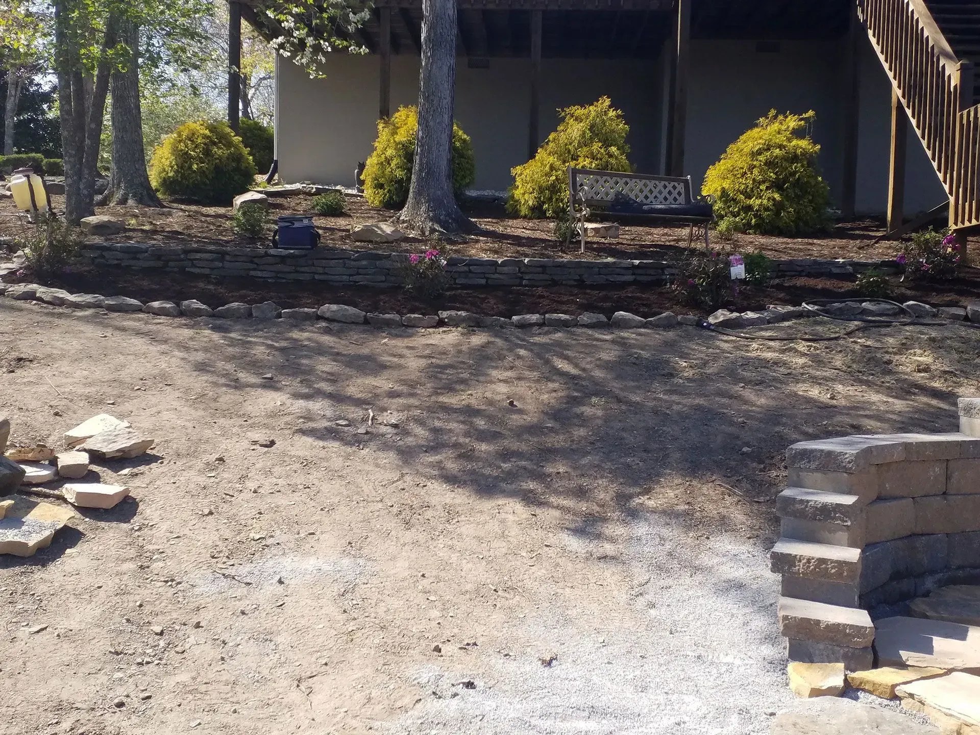 A house with a staircase and a stone wall in front of it