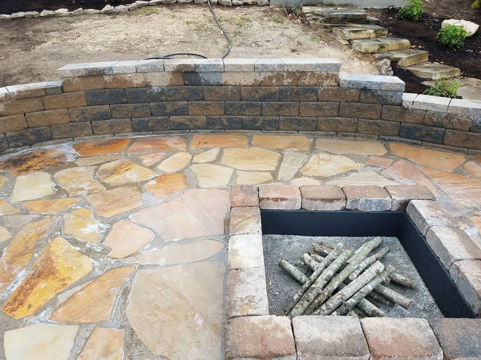 A fire pit is surrounded by bricks and rocks
