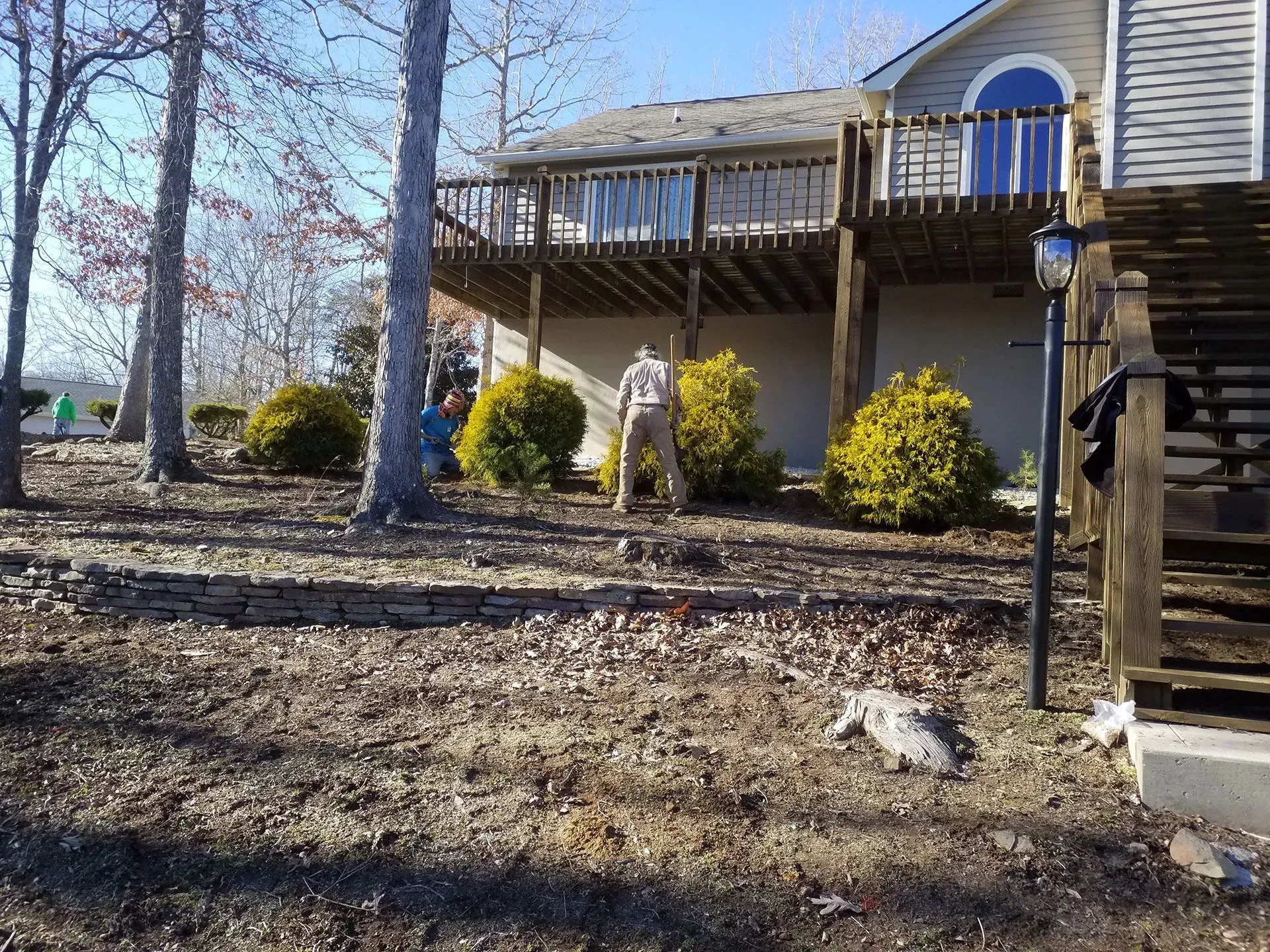 A man is standing in front of a house with a large deck