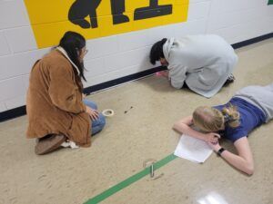 A group of people are kneeling on the floor in front of a yellow sign that says td.