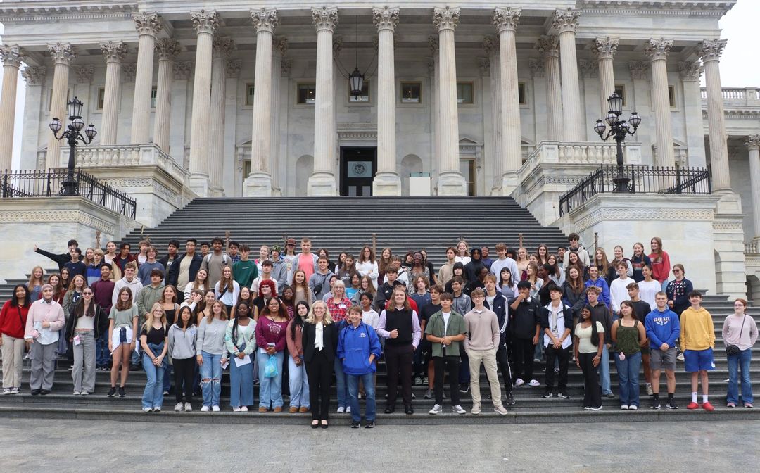 A large group of people standing on the steps of the capitol building