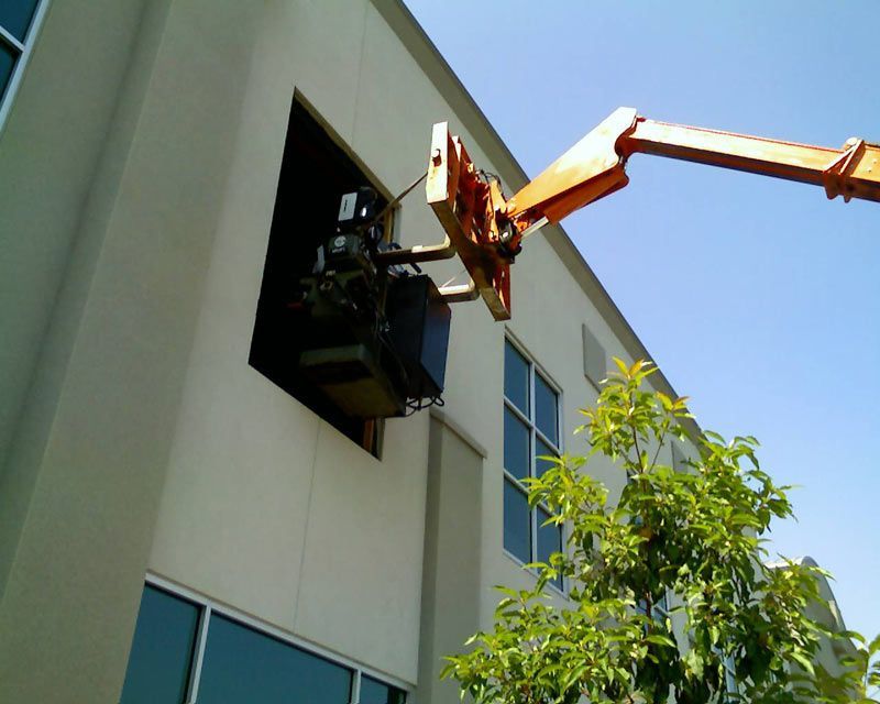 A Crane is Lifting Something Out of the Window of a Building | San Rafael, CA | Earl Farnsworth Express