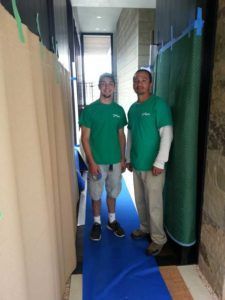 Two Men in Green Shirts are Standing next to each other in a Hallway | San Rafael, CA | Earl Farnsworth Express