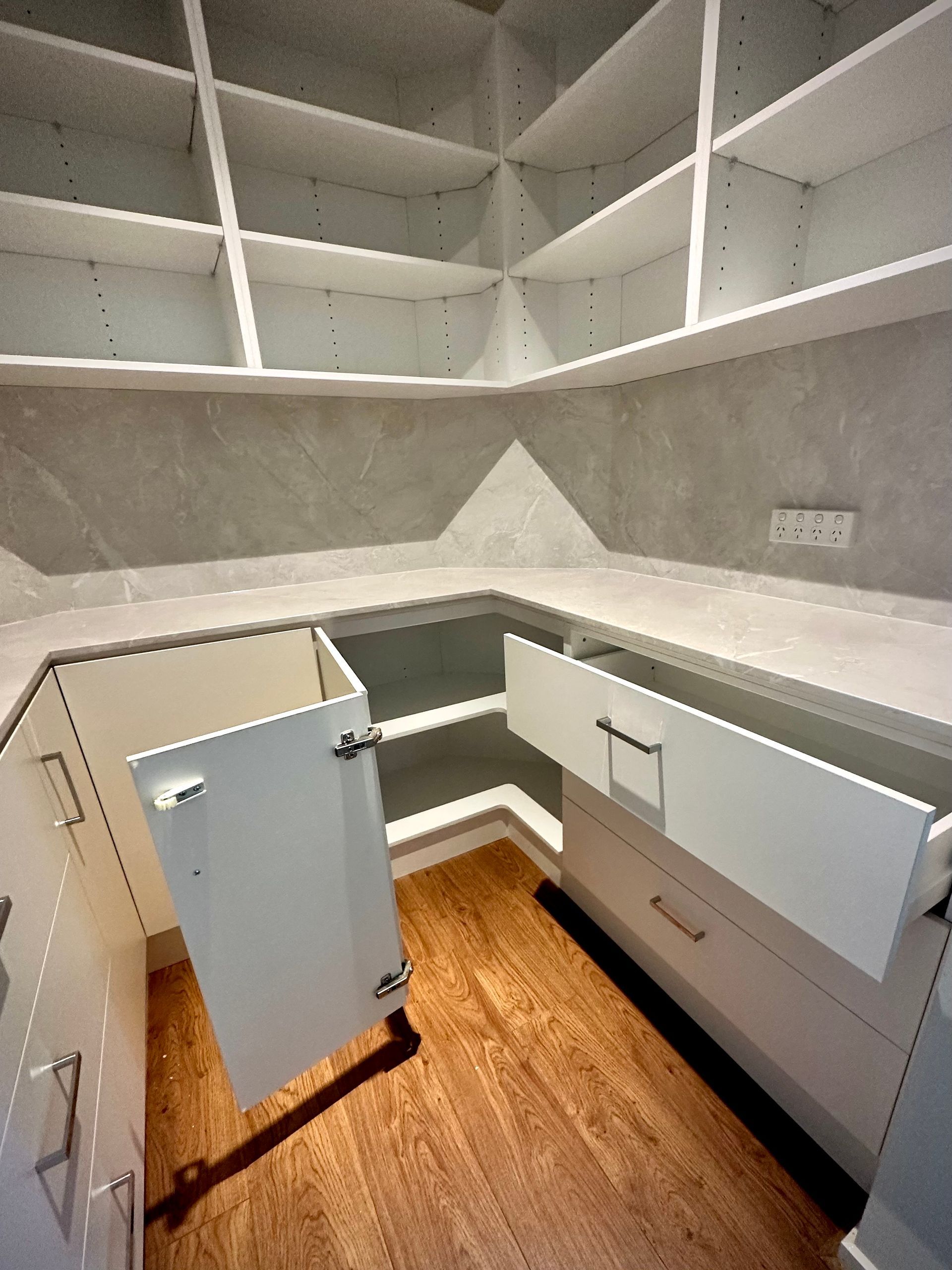 A pantry with a drawer open and shelves open