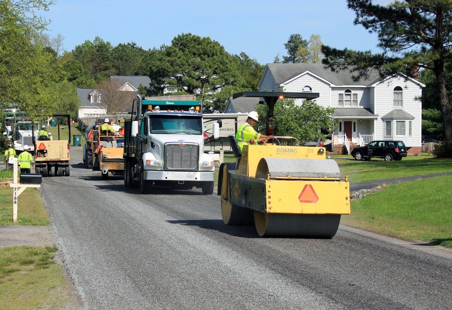 Chip seal equipment lined up on a neighborhood street.