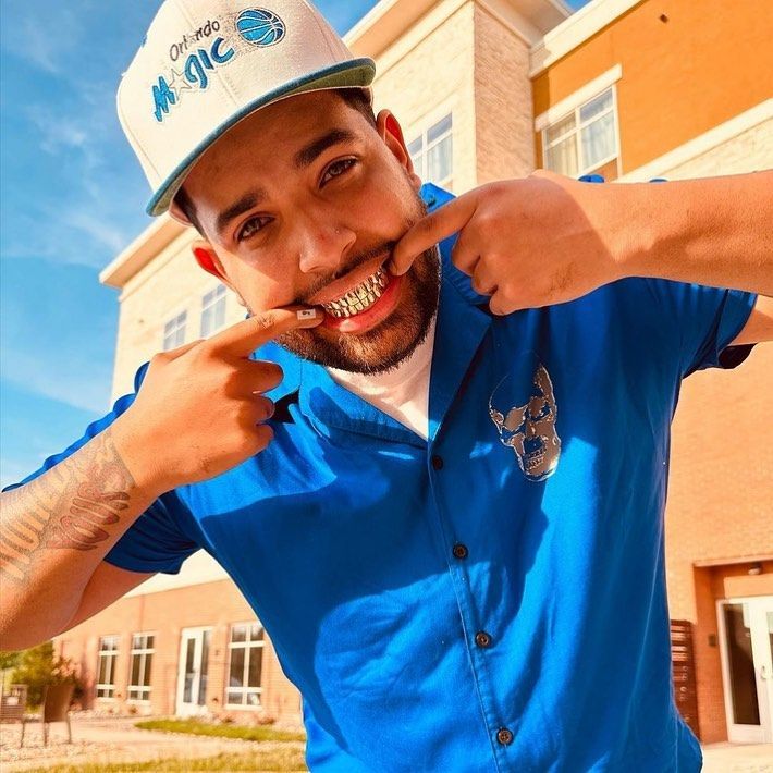 Smiling client wearing full custom gold grillz teeth in South Florida
