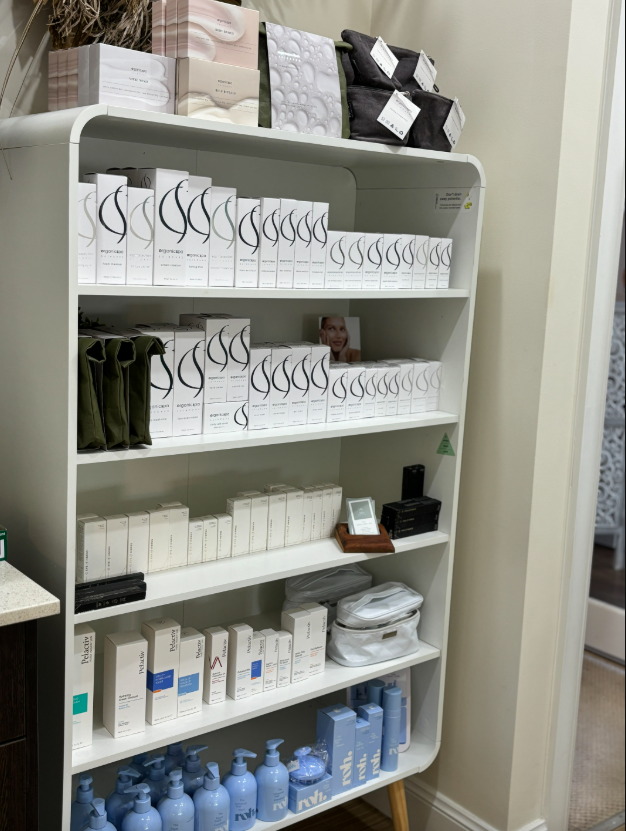 White shelving unit stocked with various skincare products in white and blue packaging.