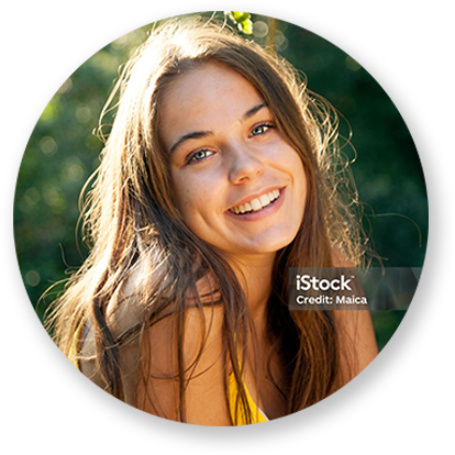 Woman with long brown hair smiles broadly outdoors.