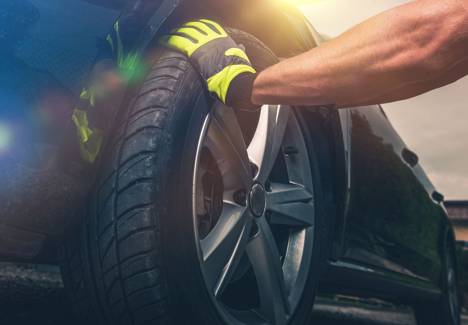 A person is changing a tire on a car.