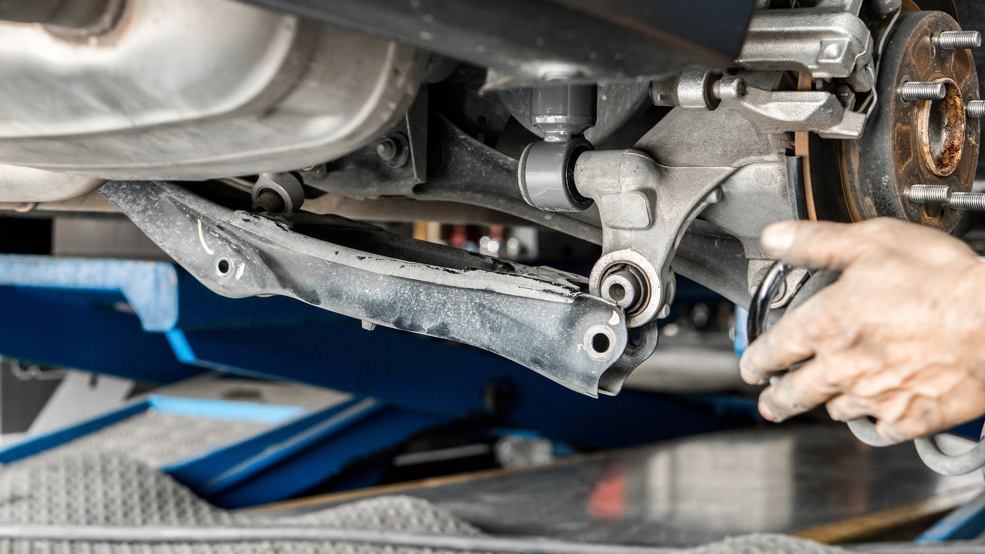 A person is working on the underside of a car.