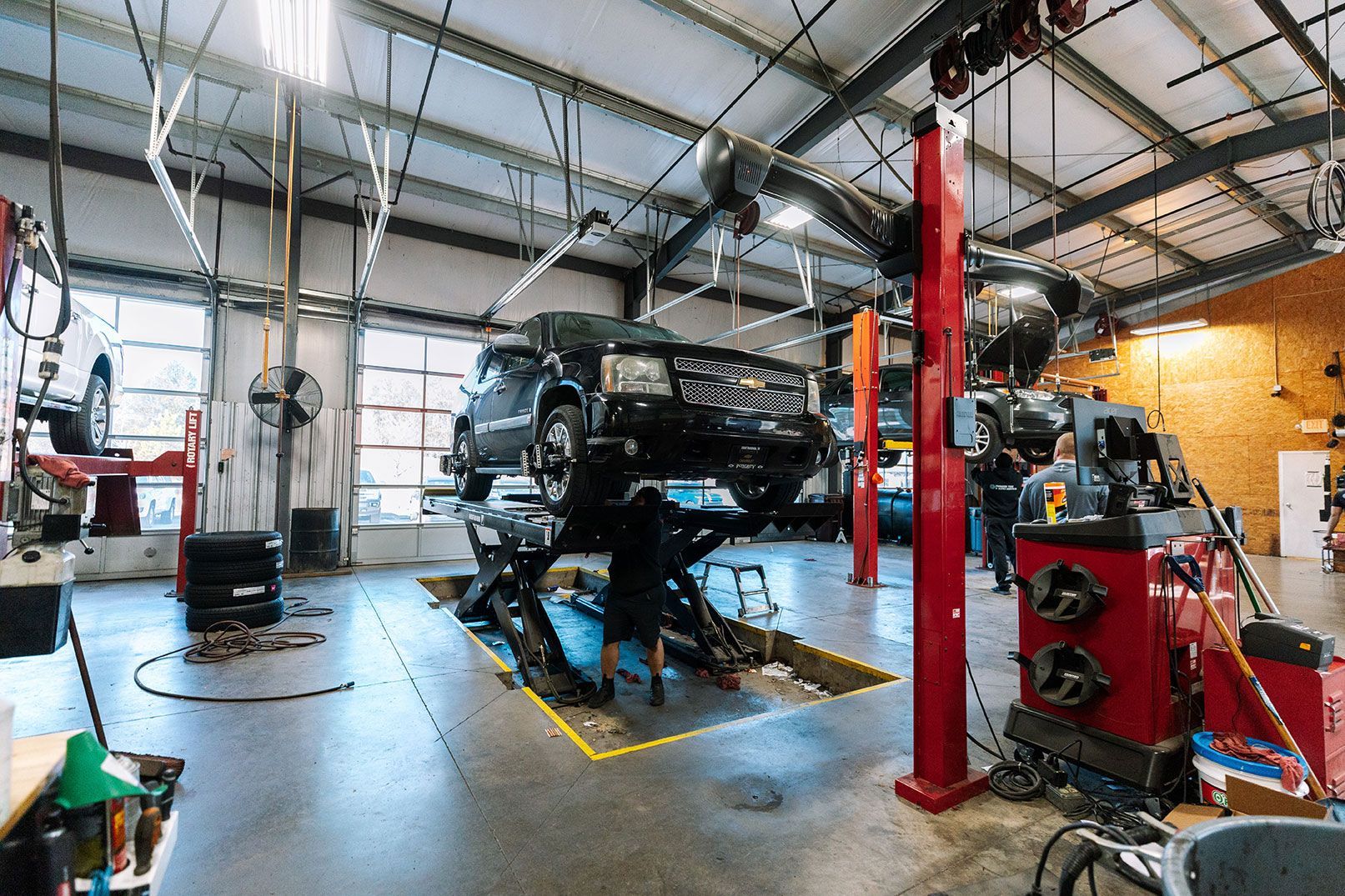 A car is sitting on a lift in the Premier Tire & Auto Service garage.