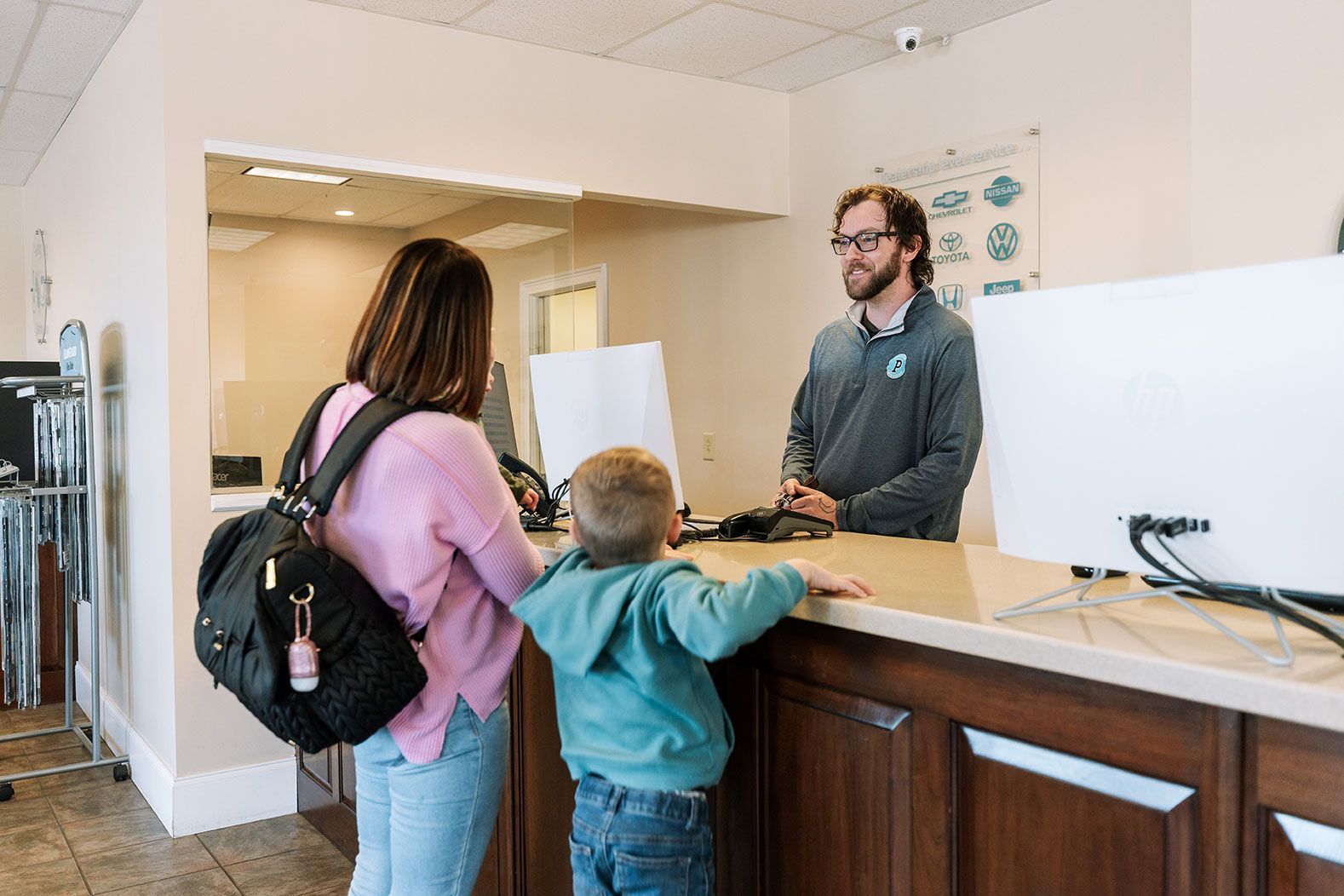 A woman and a child are standing at the Premier counter