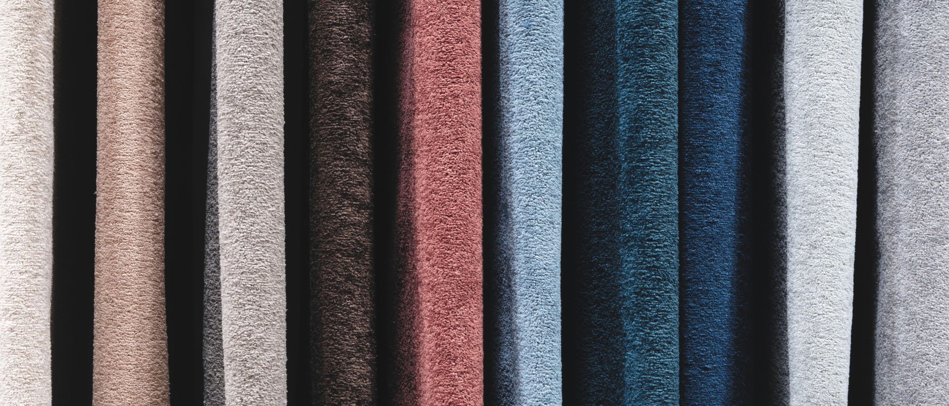 A row of different colored carpet samples