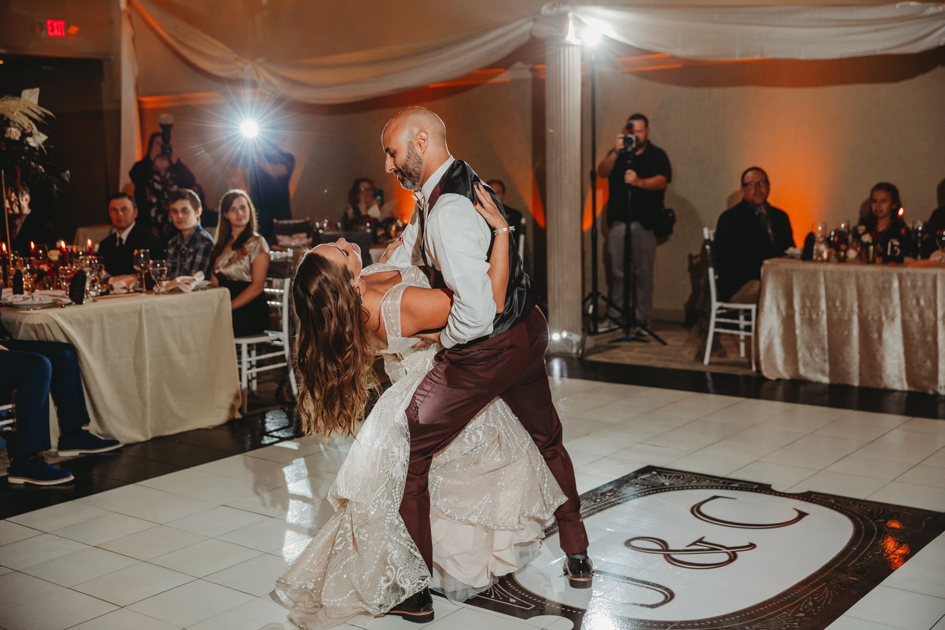Bride and groom dancing on a decorated dance floor at a wedding reception.