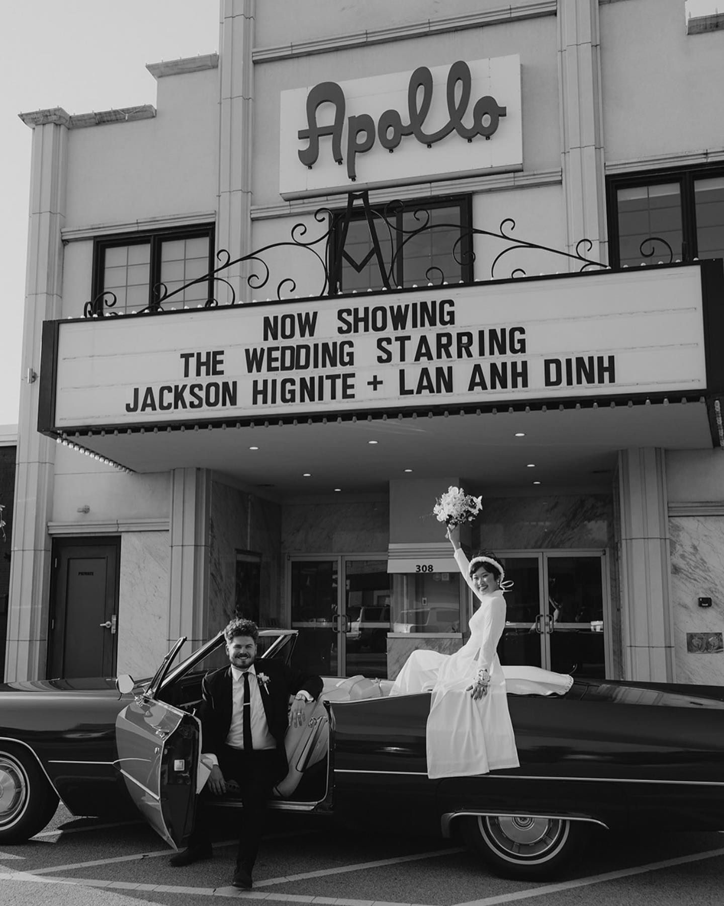 Bride and groom pose in front of the Apollo Theater, the marquee reads 