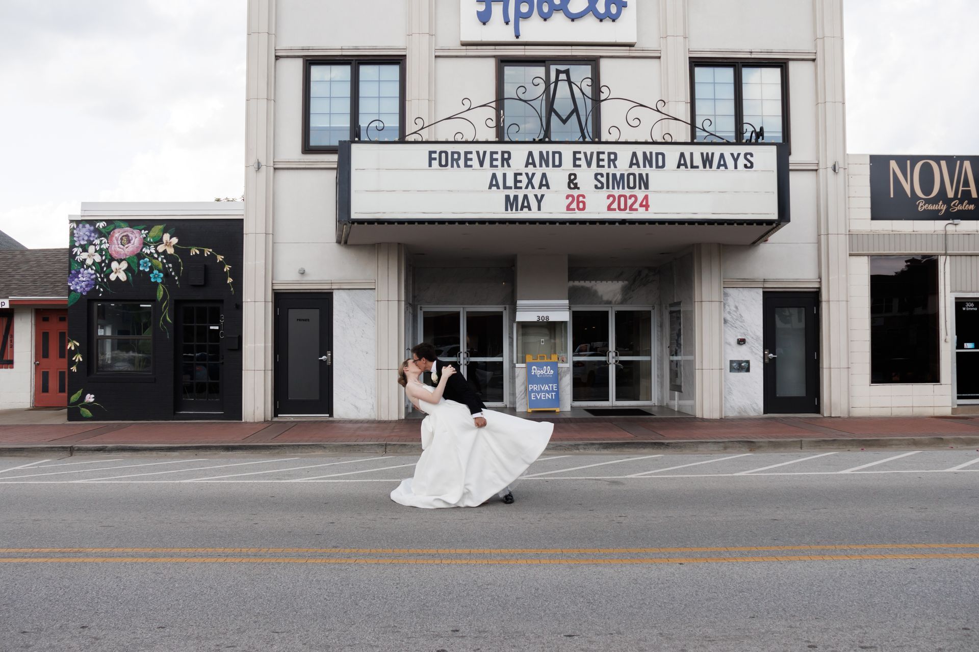 Bride and groom kissing in front of a theater with 
