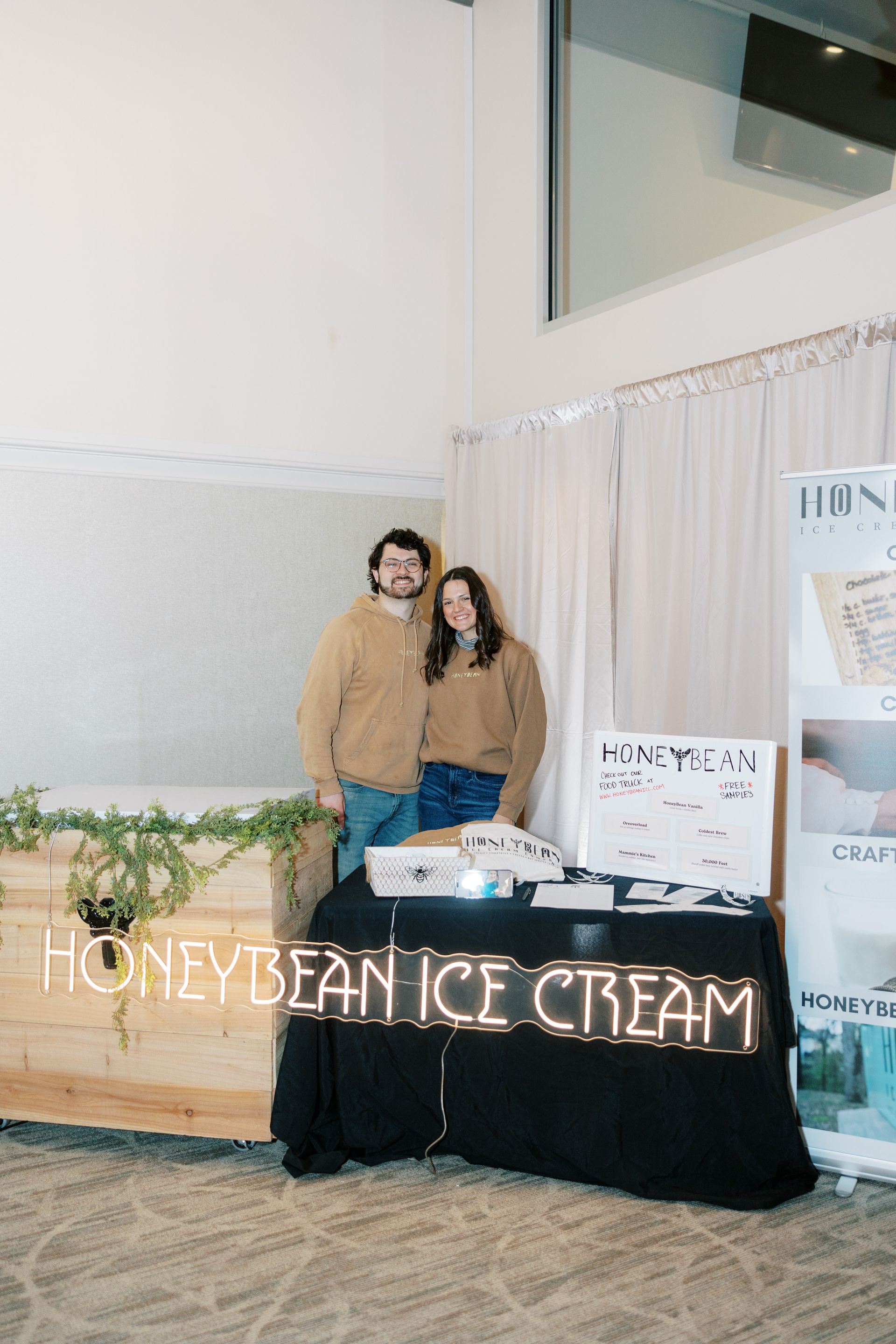 Two people stand behind a table with 