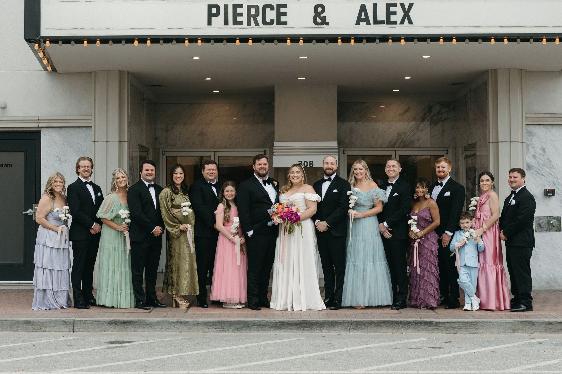 Wedding party outside a theater with marquee 