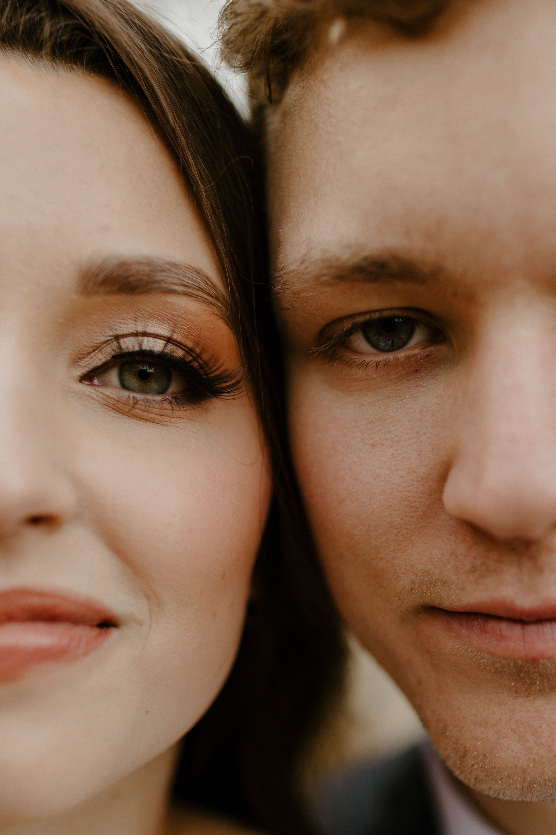 Close-up of a couple's faces, split down the middle. One eye is made up, other is plain. Both are looking forward.