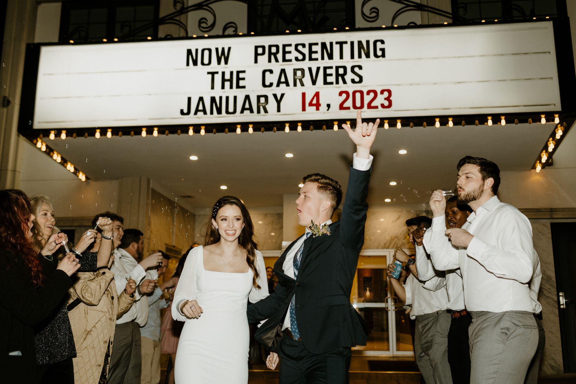 Long table set for an event with purple napkins and floral centerpieces.