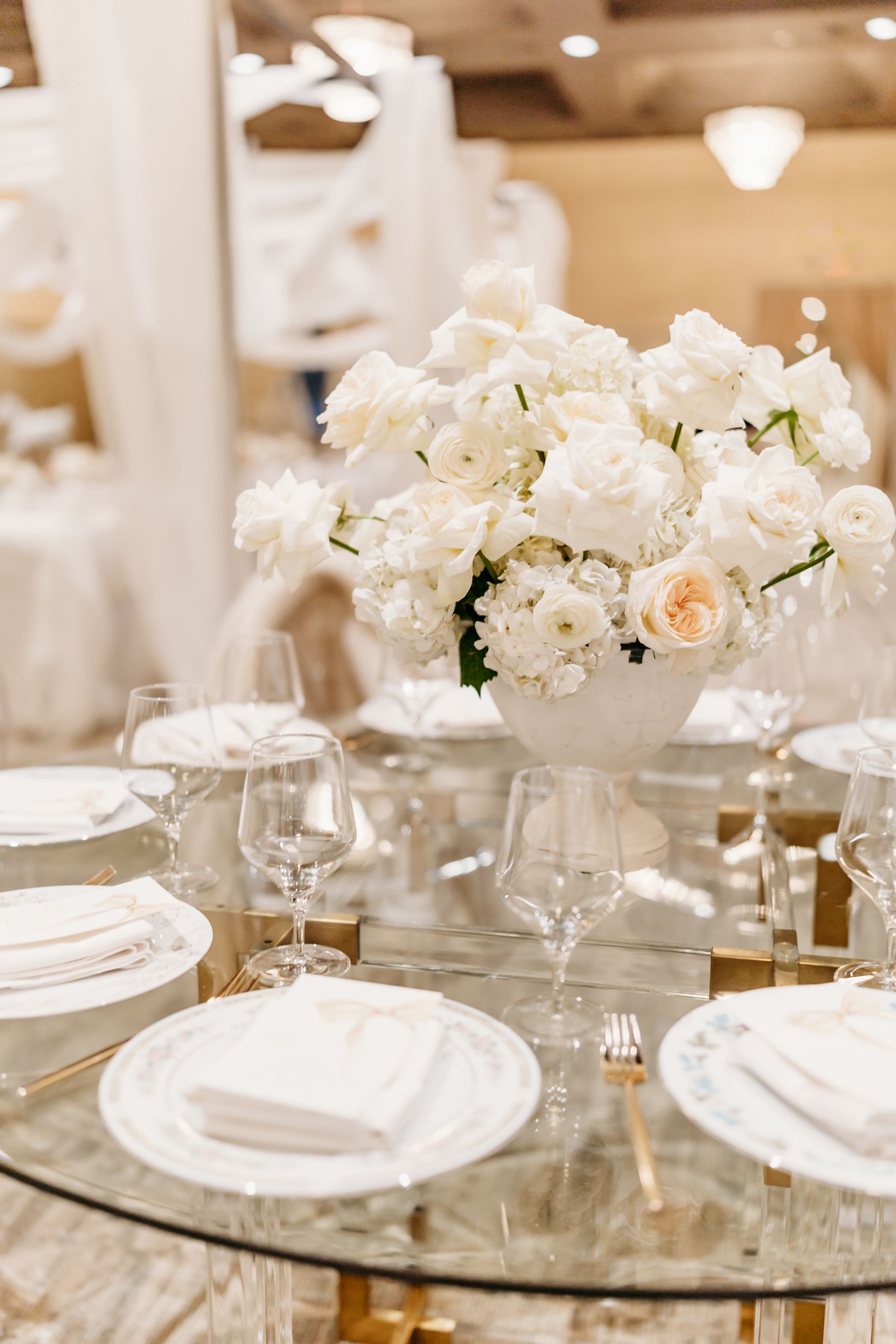 Round table set with white floral centerpiece and place settings.