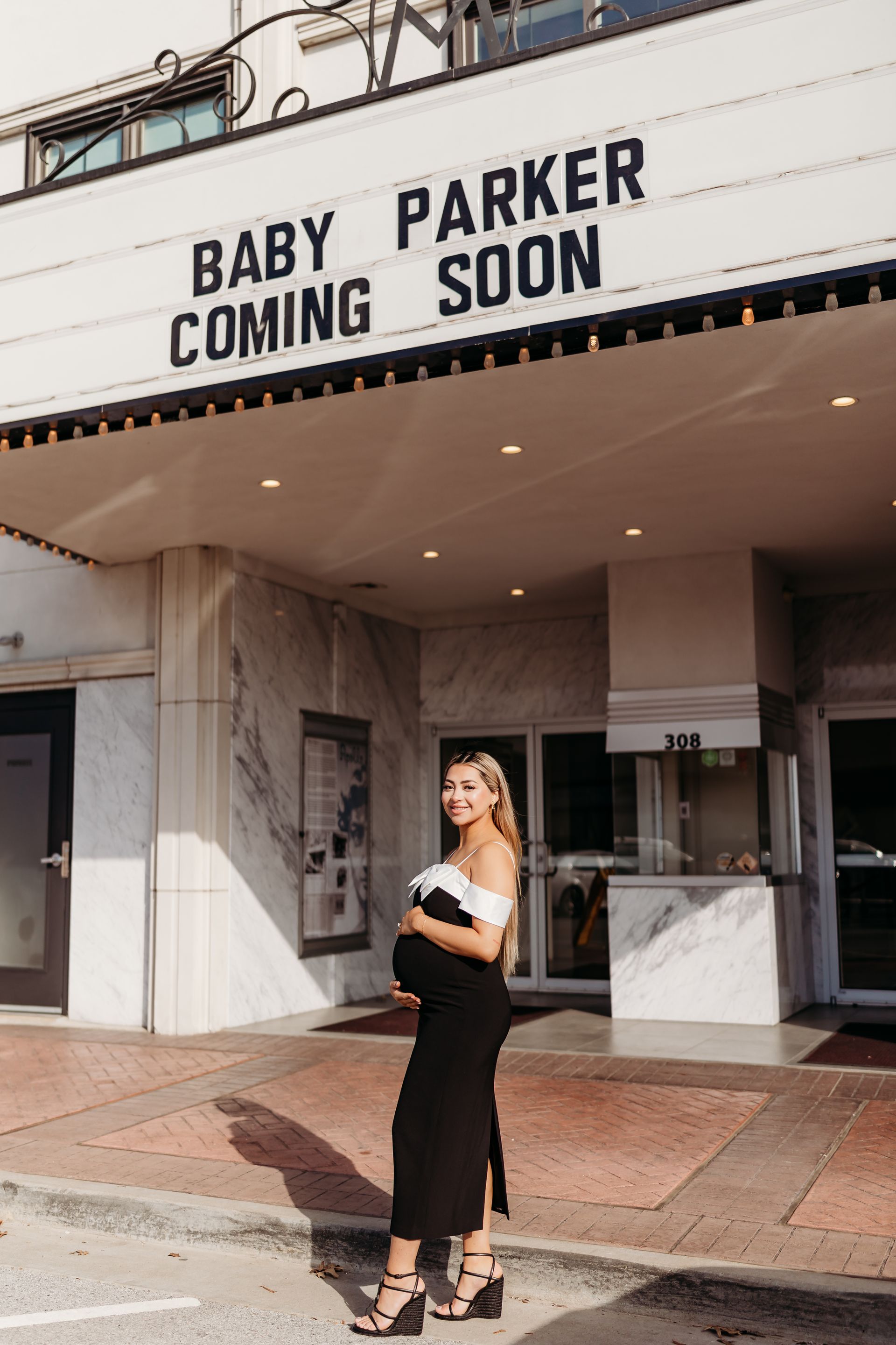 Pregnant woman in front of a marquee that reads 