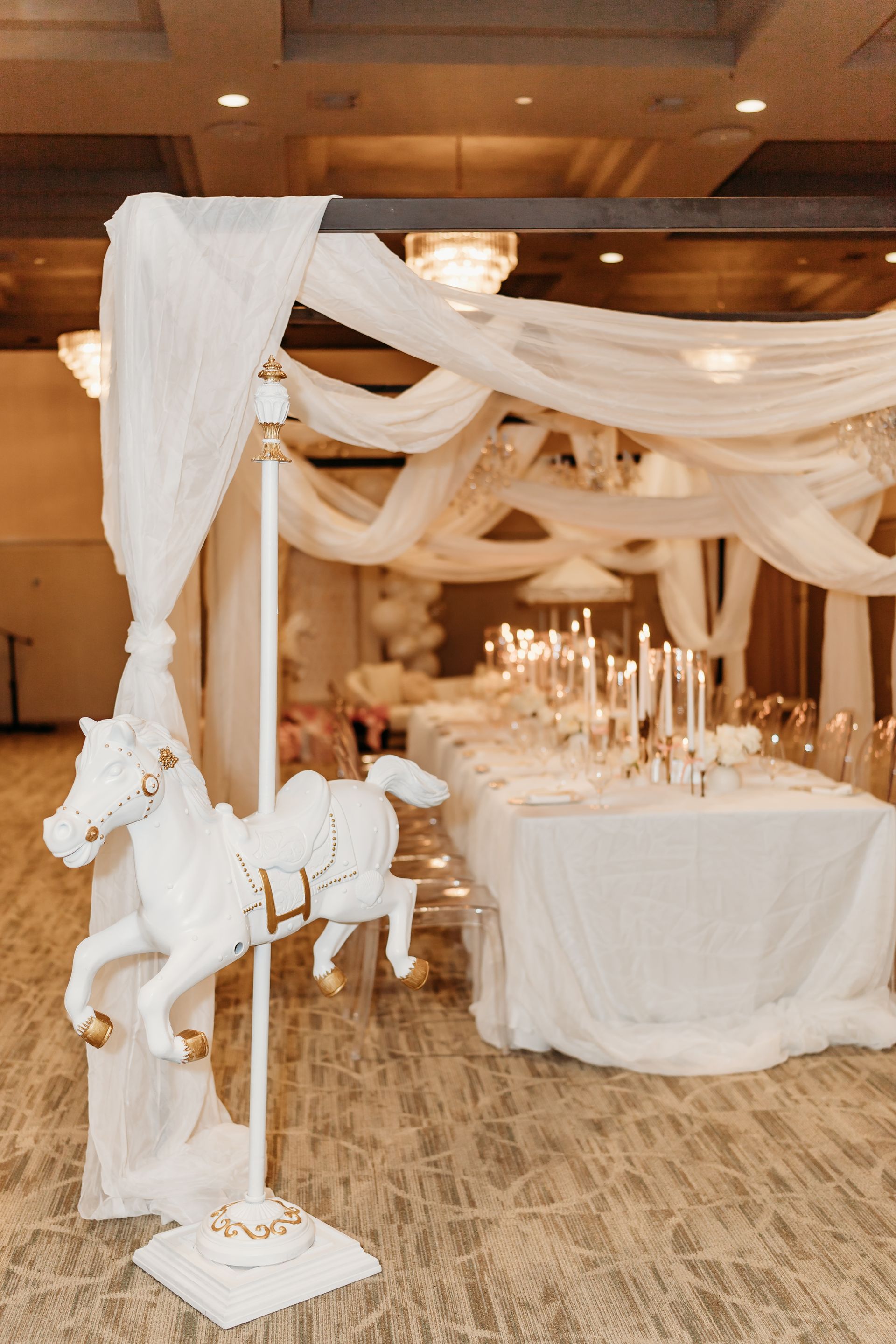 Long table set for an event with purple napkins and floral centerpieces.