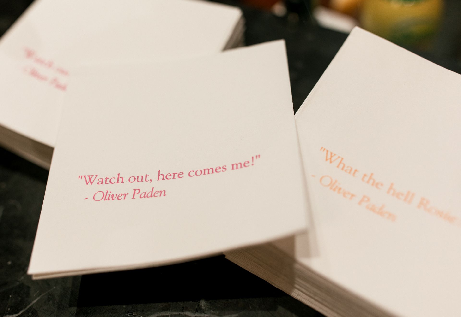 White napkins with quotes by Oliver Paden in pink text.