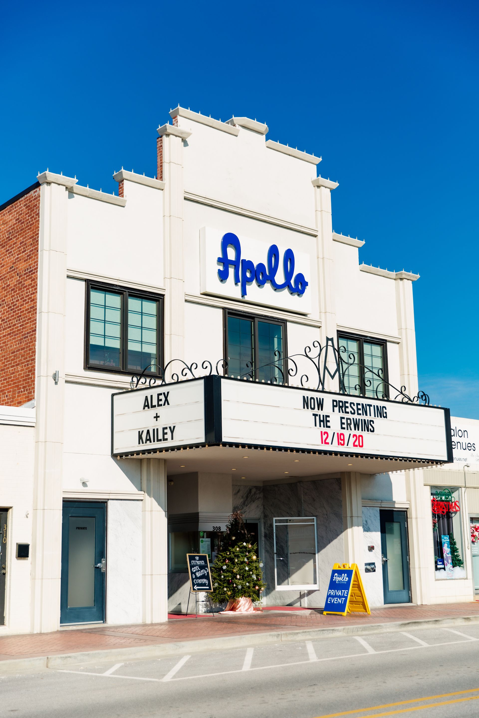 Apollo Theater facade with marquee, white building, blue lettering, sunny day.