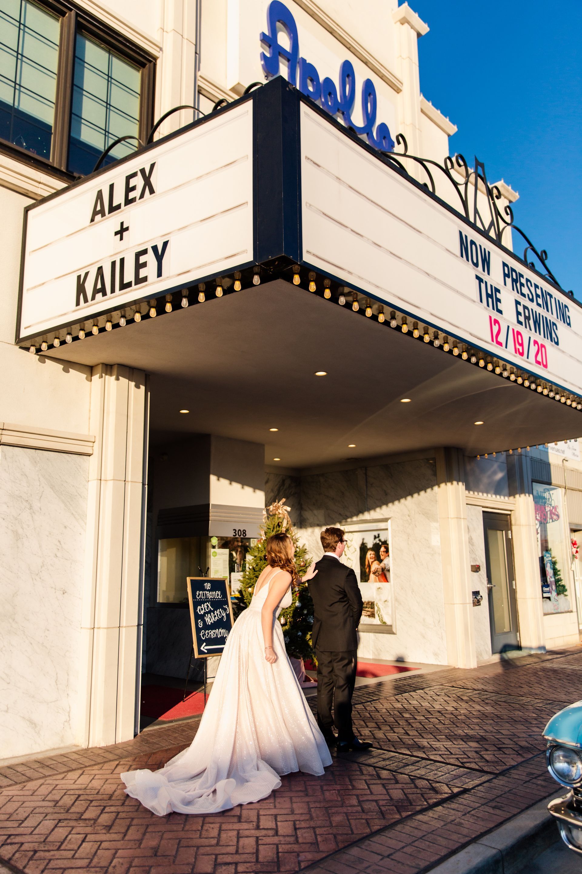 Bride and groom at the Apollo Theatre entrance. Marquee reads 