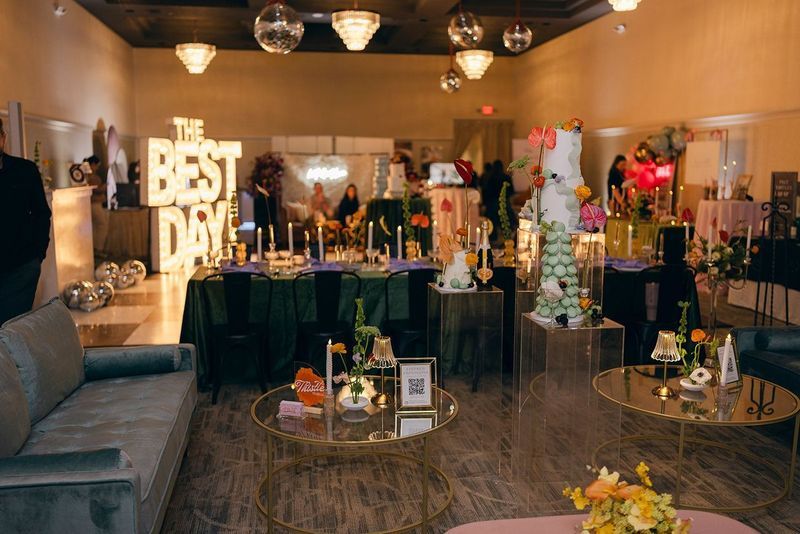 Event space with cakes, tables, decor, and a “BEST DAY” sign.