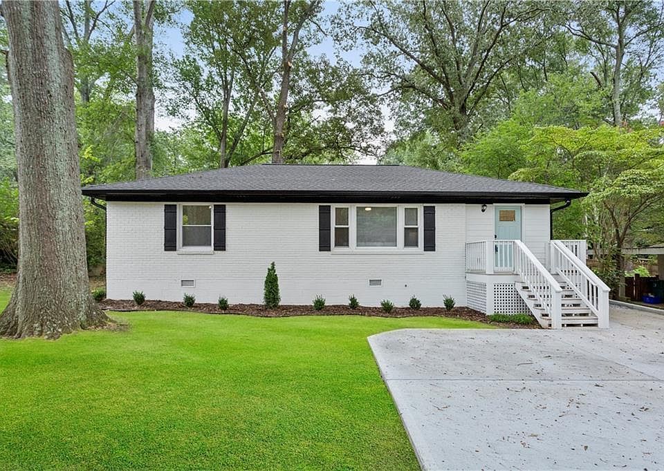 A large white house with a lush green lawn in front of it
