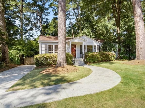 A large white house with a lush green lawn in front of it.