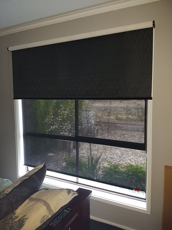 A Bedroom With A Bed And A Window With Black Blinds — Carpets & Flooring in Queanbeyan, NSW