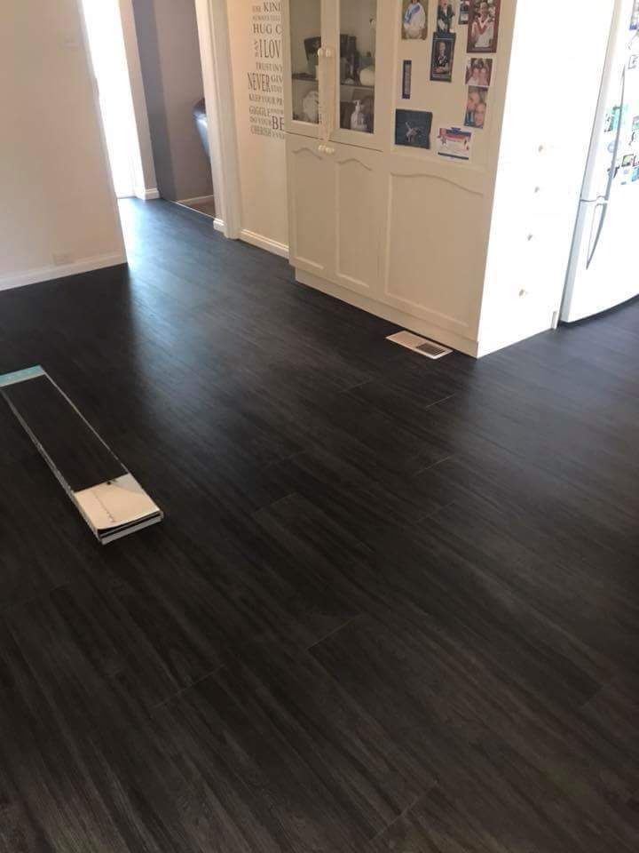 A Black Wooden Floor Is Being Installed In A Kitchen — Flooring in Queanbeyan, NSW