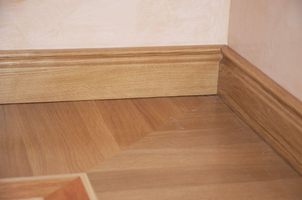 Wooden Floor Meeting a Wood Baseboard and Corner Trim — Queanbeyan Carpets in Queanbeyan, NSW