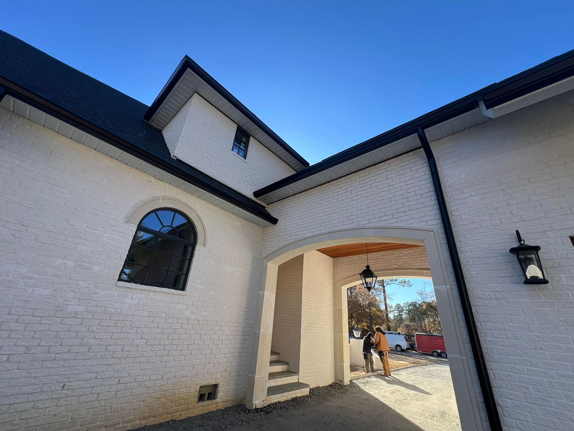 A white brick building with a blue sky in the background.