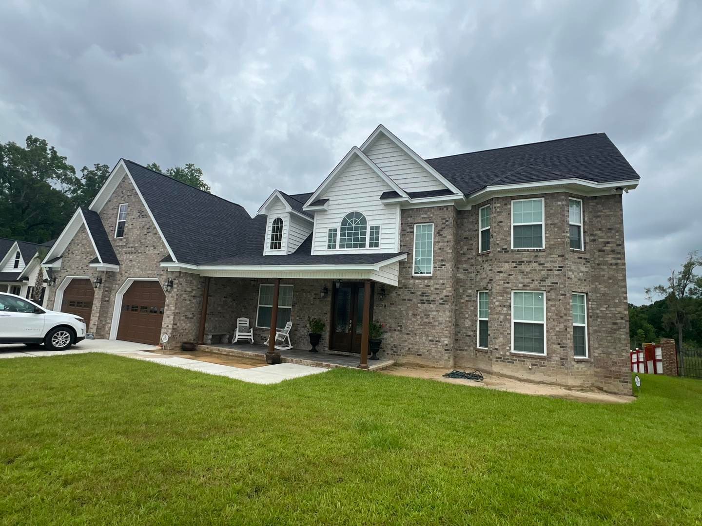 A large brick house with a car parked in front of it.