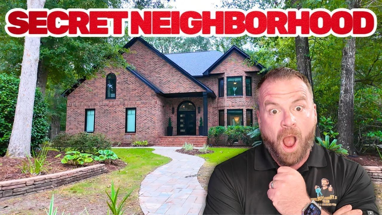 Man with surprised expression in front of a brick house with