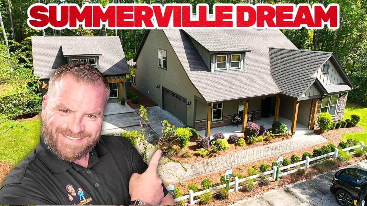 Man points toward a house with a garage and another building.