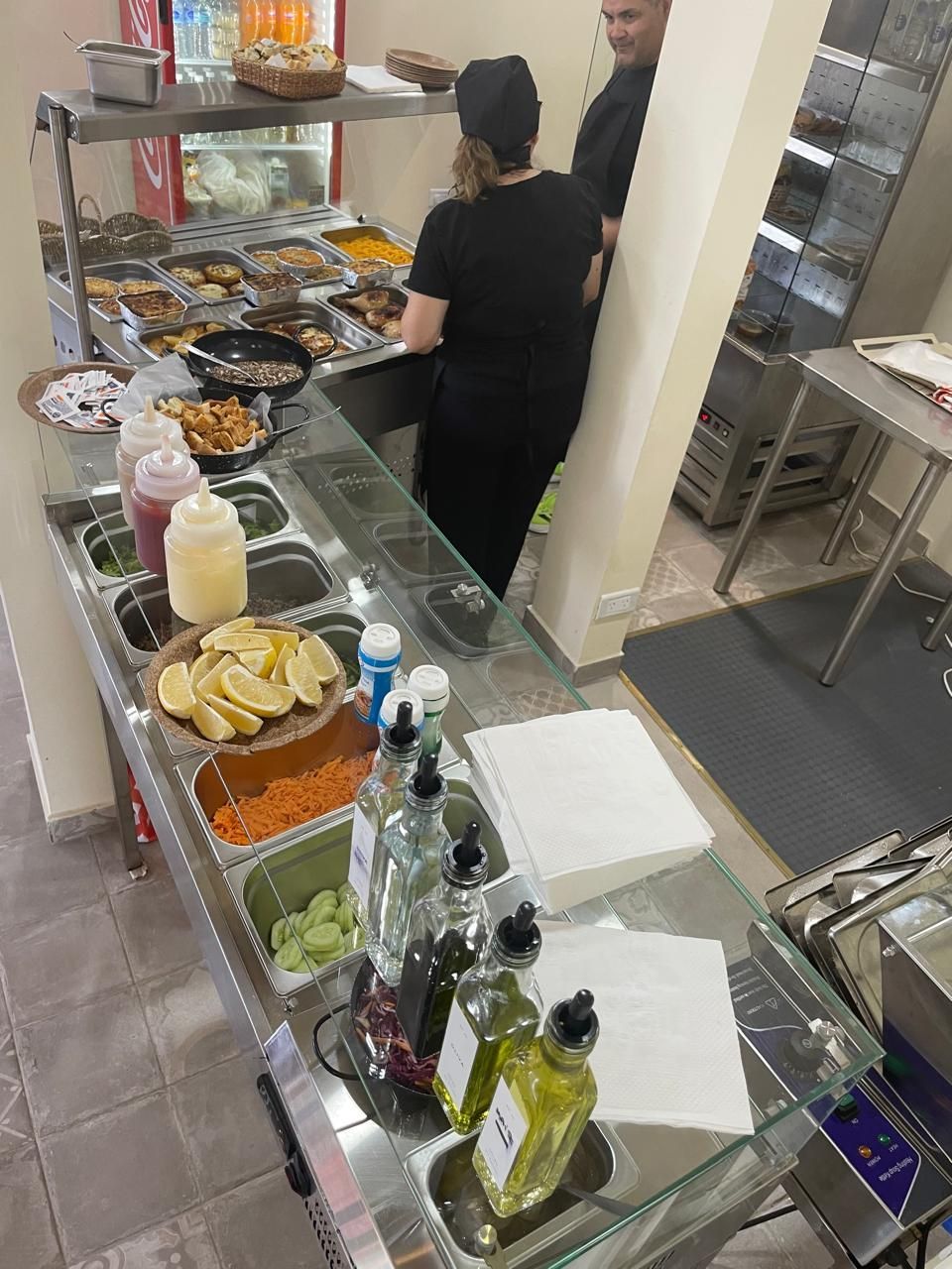 Un puesto de servicio de alimentos con una exhibición de ingredientes como limones y verduras