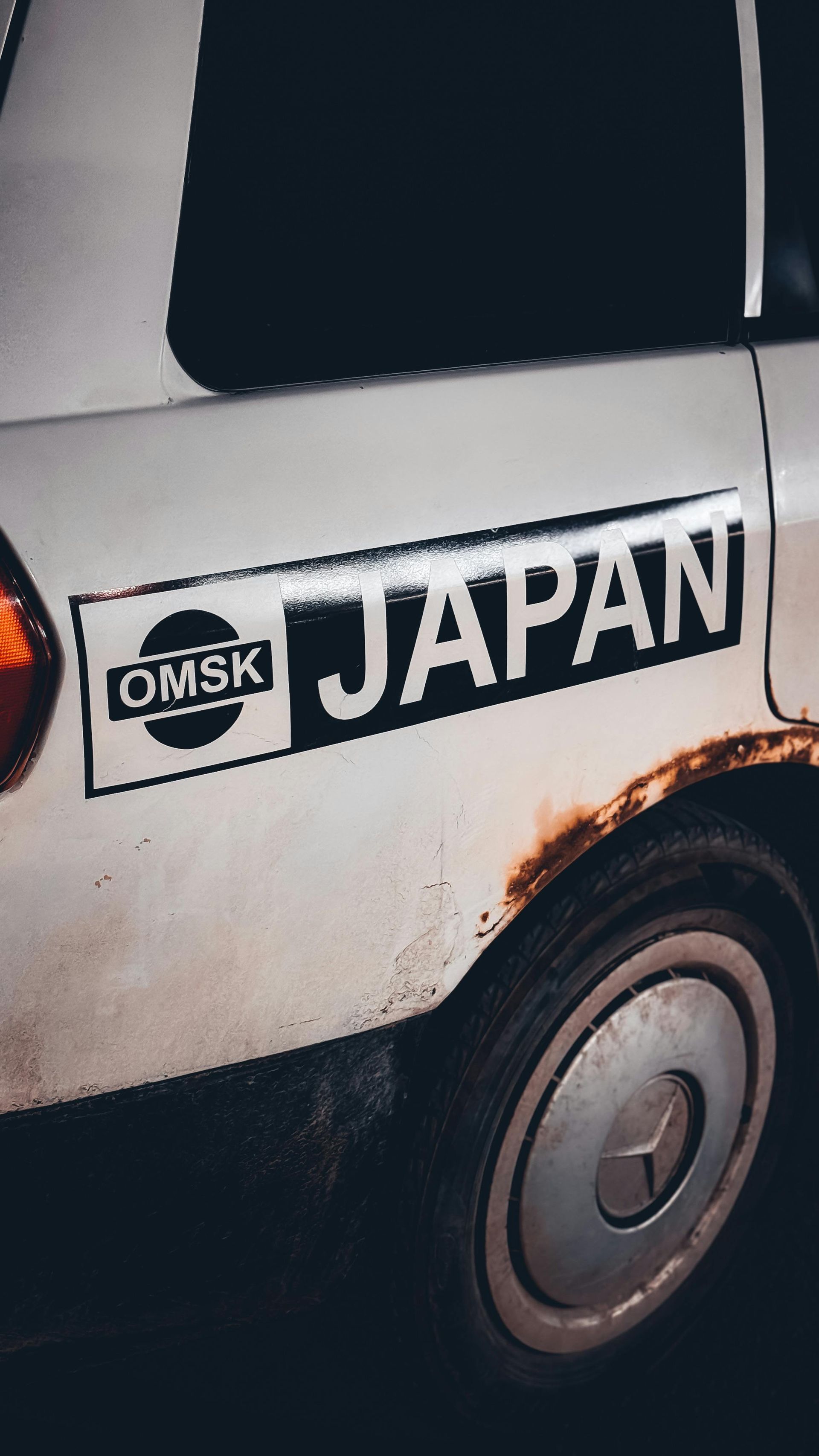 A white car with a sticker on the side that says japan.