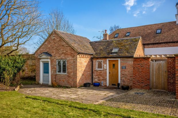 A brick house with a garage and a driveway in front of it.