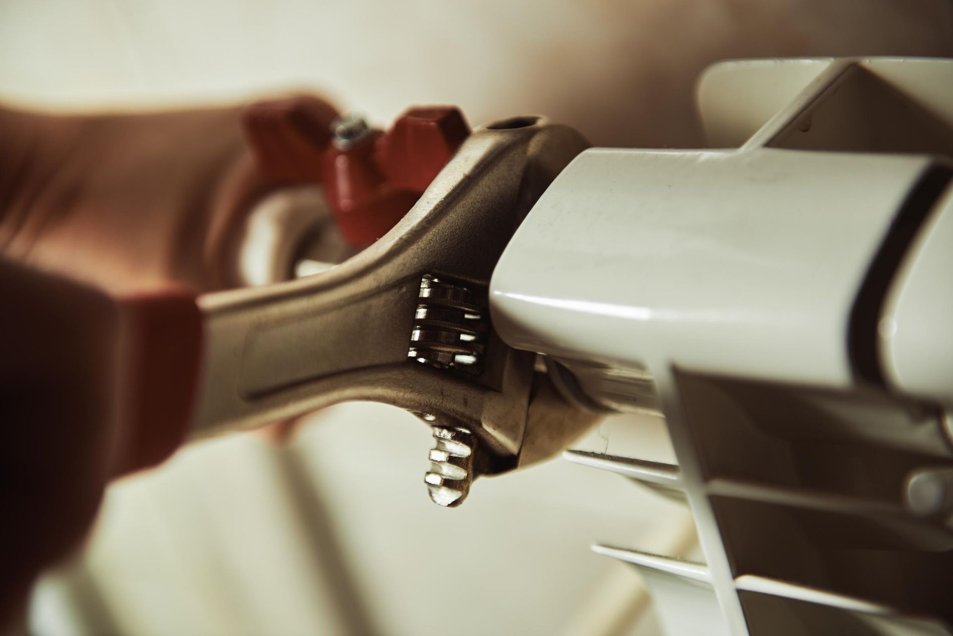 Hand Using a Wrench on A White Radiator, Water Drop Visible — Joy Hire Compressor Hire & Maintenance in Paget, QLD
