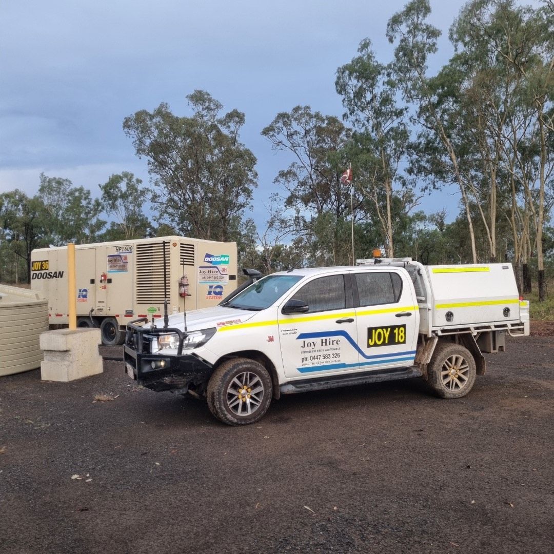 White Utility Truck With “Joy 18” Signage, Parked Near a Generator in a Rural Setting — Joy Hire Compressor Hire & Maintenance in Paget, QLD