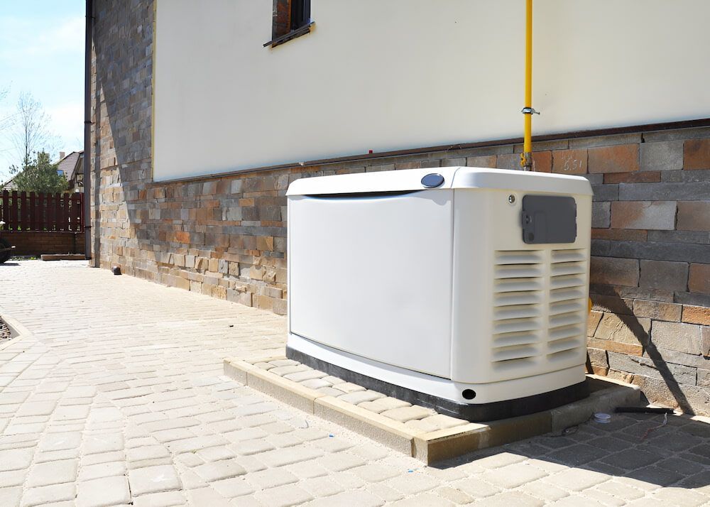 A White Generator Is Sitting On The Side Of A Building — Joy Hire Compressor Hire & Maintenance in Bowen, QLD