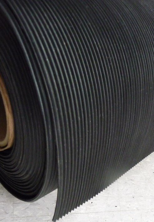 A roll of black rubber is sitting on a table.