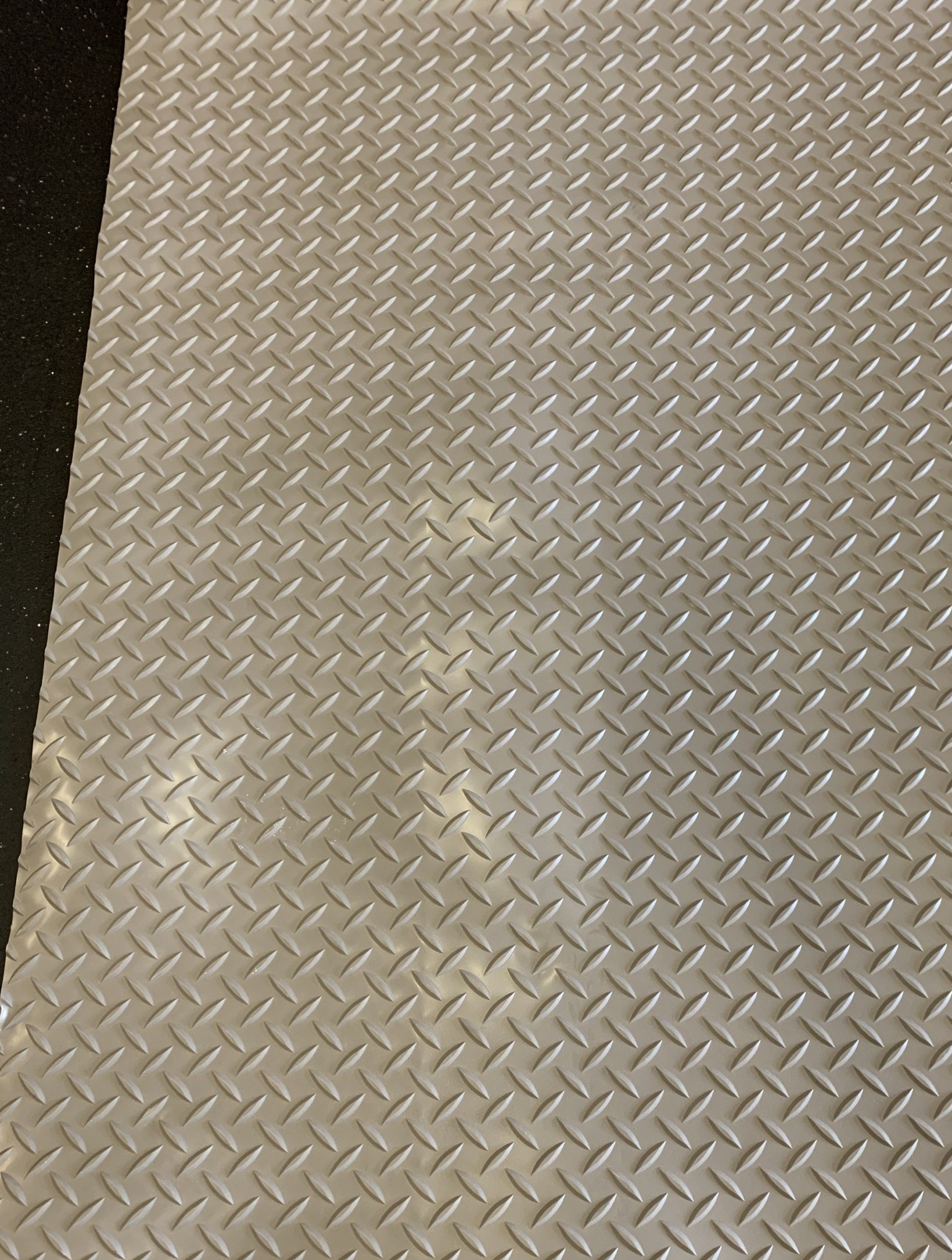 A close up of a metal floor with a herringbone pattern.