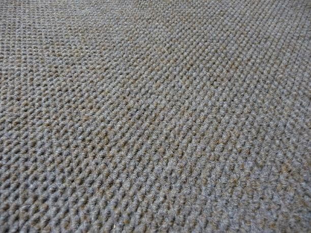 A close up of a rug with a knitted pattern on it.